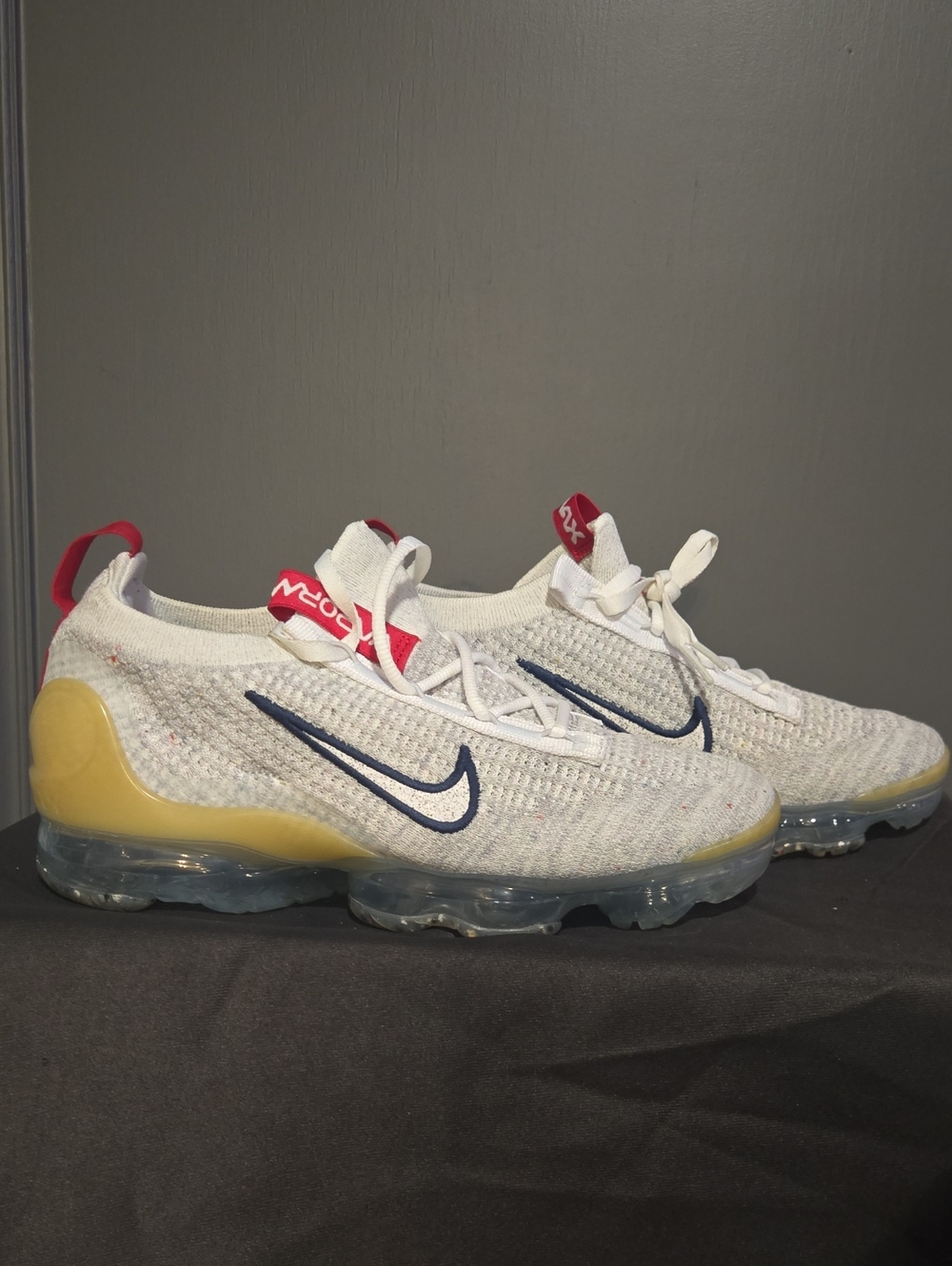 Nike White Flyknit Sneakers with Navy Swoosh and Yellow Heel Tab